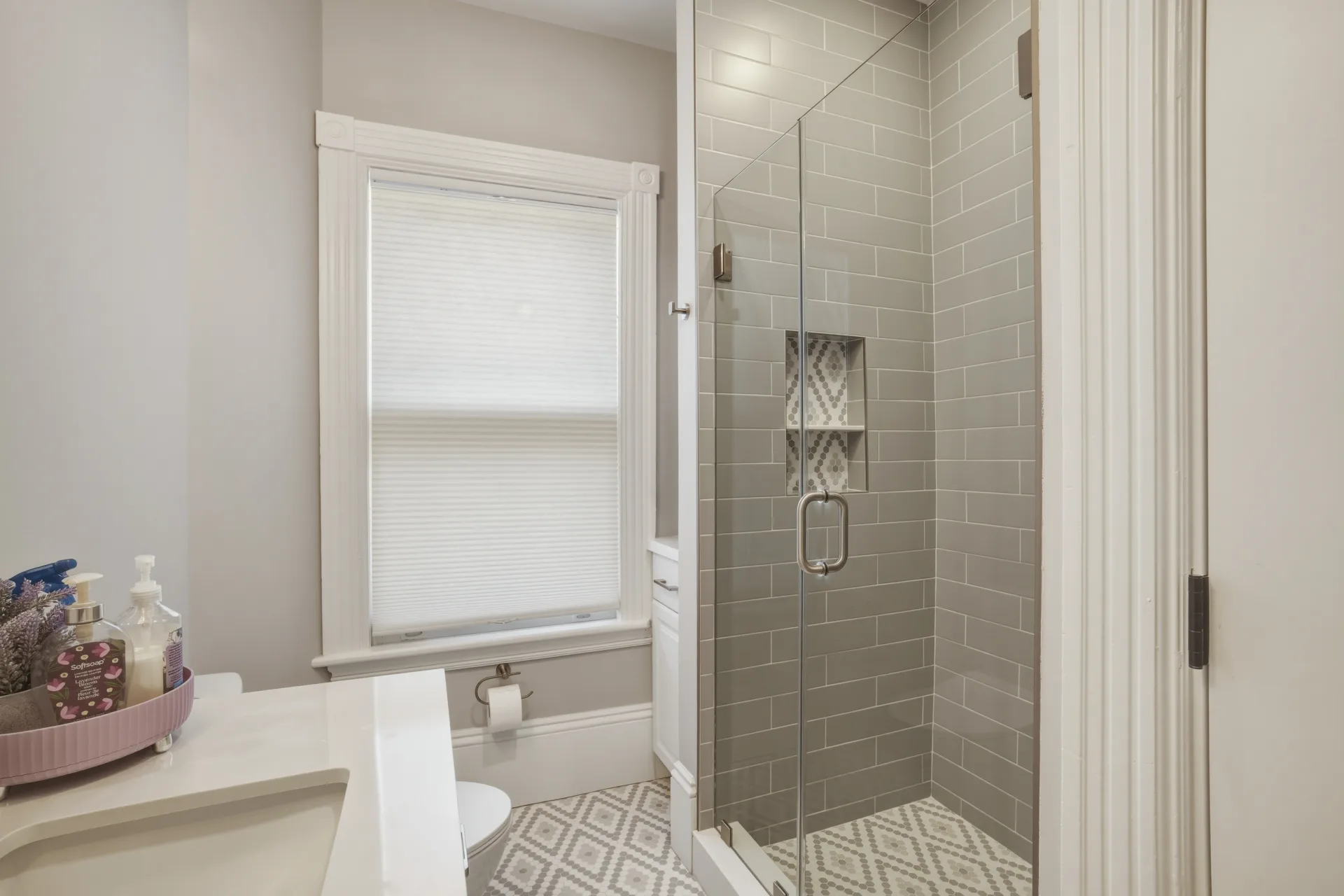 Bathroom renovation with a glass shower and gray tile